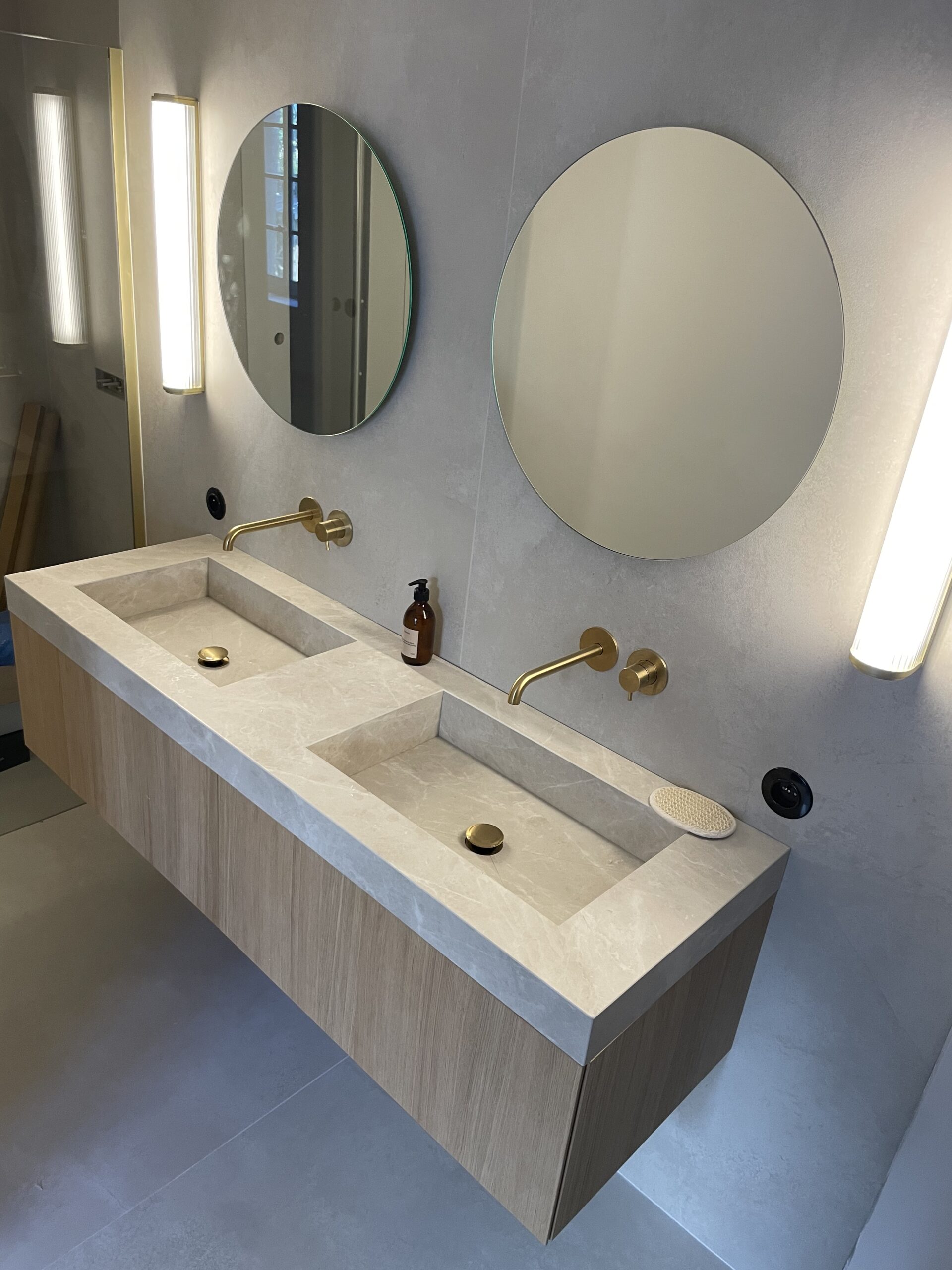 Meuble suspendu au style moderne et minimaliste avec robinetterie encastrée et double vasques.